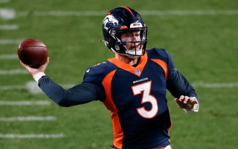 Drew Lock throwing a ball in Broncos jersey.
